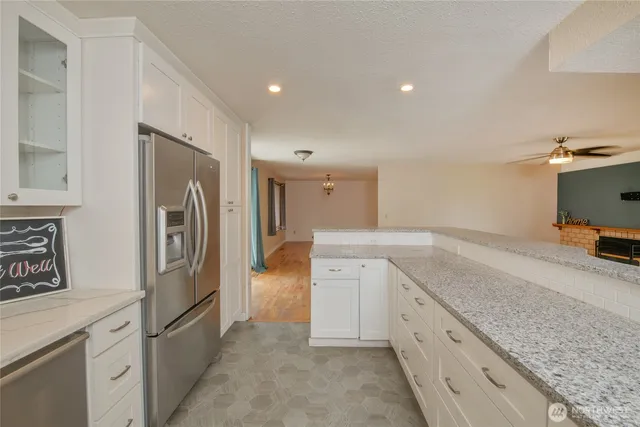 a kitchen with granite countertop cabinets and refrigerator