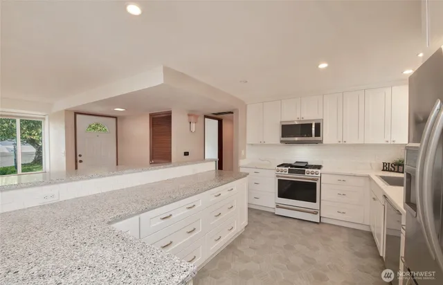 a kitchen with a refrigerator a microwave a sink and a stove