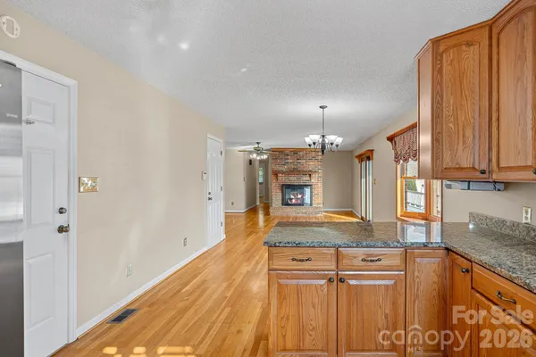 a view of a kitchen with kitchen island a sink wooden floor and counter top space