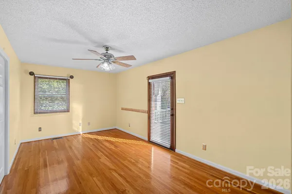 an empty room with a window and a ceiling fan