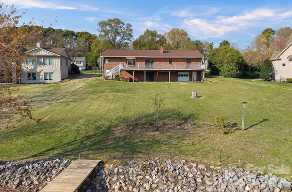 a view of a big house with a big yard and large trees