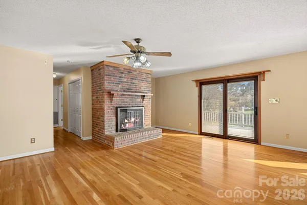 a view of an empty room with a fireplace and a window