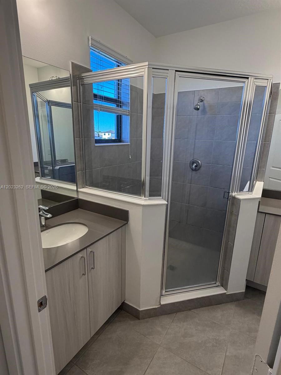 5669 Cerva Lane, Unit 5669 Immokalee, FL 34142 - Photo 18 of 32 a bathroom with a sink a mirror and a shower