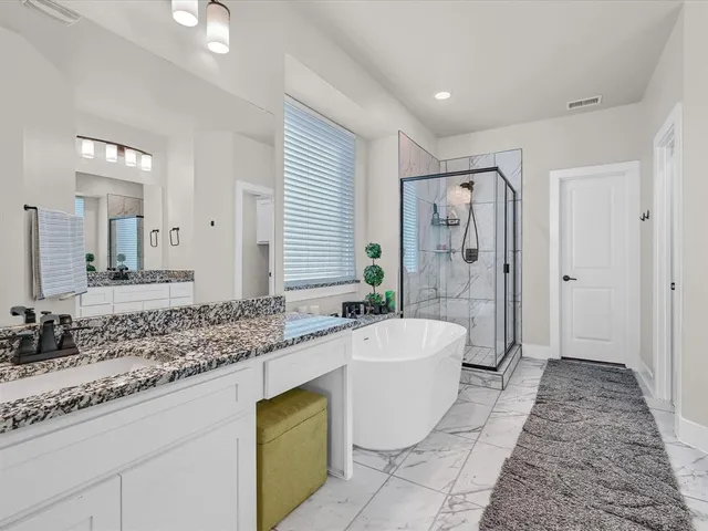 a spacious bathroom with a granite countertop tub sink and mirror