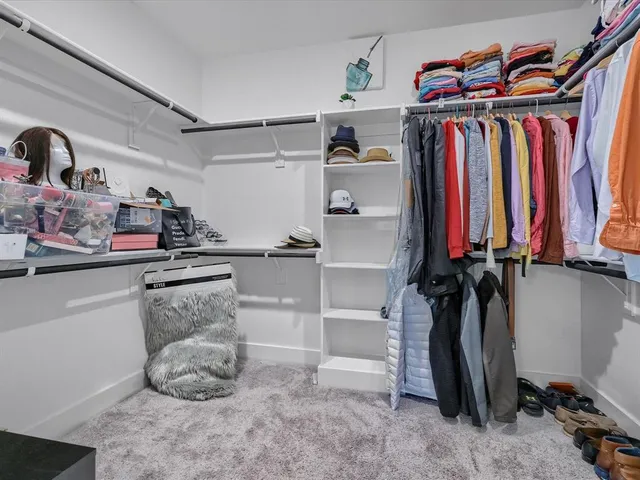 a view of walk in closet with clothes and shoes