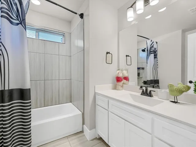 a bathroom with a bathtub sink and mirror