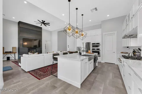 a large white kitchen with a stove a sink a refrigerator and a fireplace