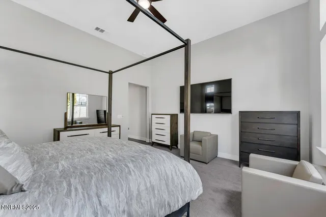 a bedroom with a bed a couch and a flat screen tv