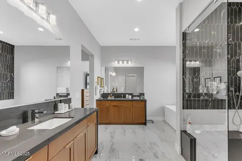a large bathroom with a granite countertop double vanity sink a mirror and a shower