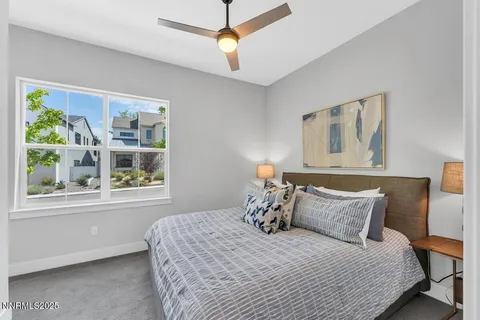 a bedroom with a bed a window and painting on the wall