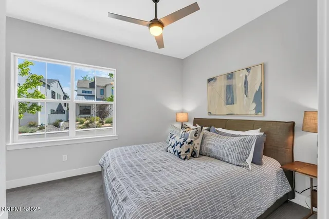 a bedroom with a bed a window and painting on the wall