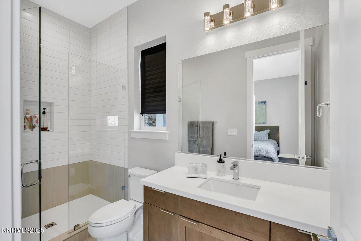 6119 South Pleasant Oak Trail Reno, NV 89511 - Photo 28 of 44 a bathroom with a sink a toilet and shower