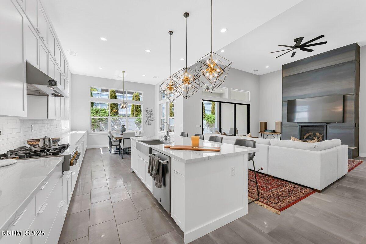 6119 South Pleasant Oak Trail Reno, NV 89511 - Photo 10 of 44 a large kitchen with kitchen island a large counter space a sink appliances and cabinets