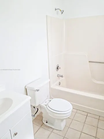 a white toilet sitting next to a bath tub