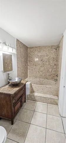 a bathroom with a granite countertop sink a toilet and bathtub