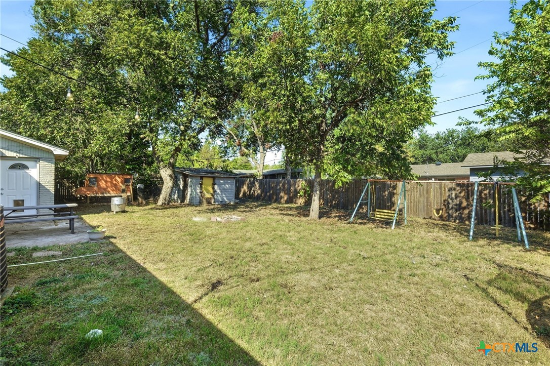 904 Kirk Street Taylor, TX 76574 - Photo 24 of 25 Back Yard with shed, chicken coop, swing set & trampoline which all convey.