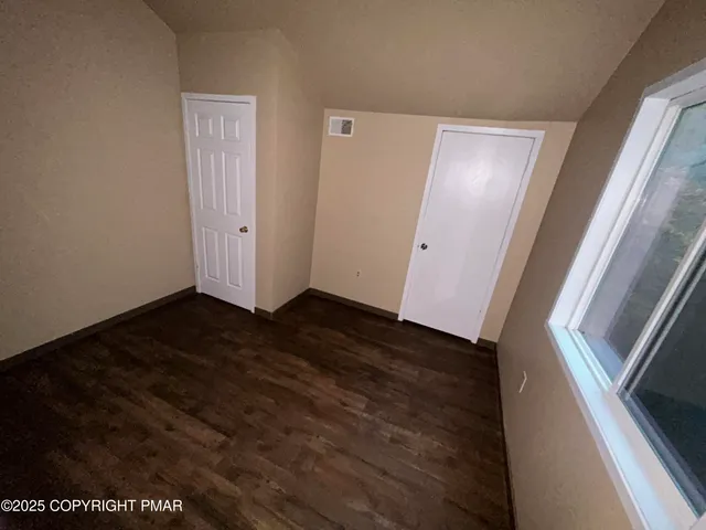 a view of an empty room and wooden floor