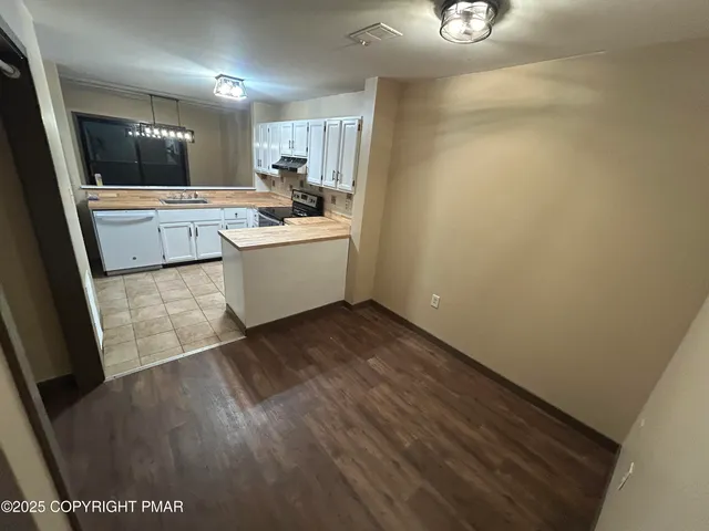 a view of a kitchen with wooden floor and a sink