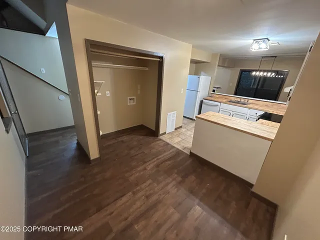 a view of a kitchen with wooden floor and electronic appliances
