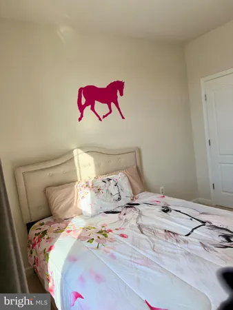 a bedroom with a bed and painting on the wall