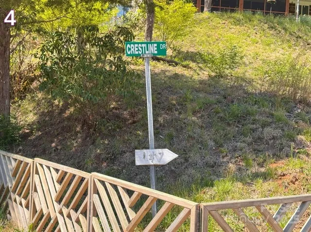 a street sign sitting on top of a wooden fence