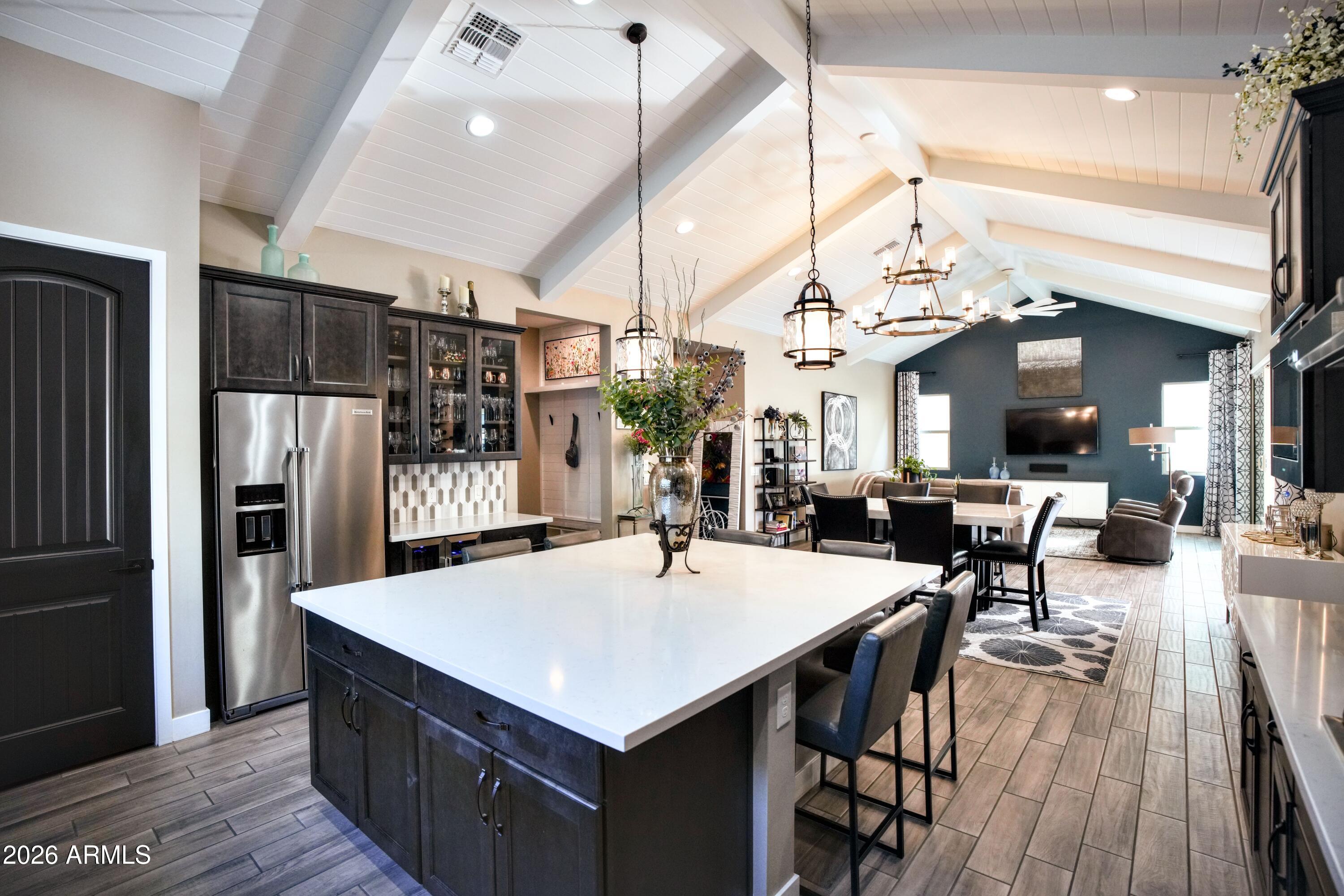 20471 West Coolidge Street Buckeye, AZ 85396 - Photo 12 of 41 a kitchen with stainless steel appliances kitchen island granite countertop a table chairs and a refrigerator