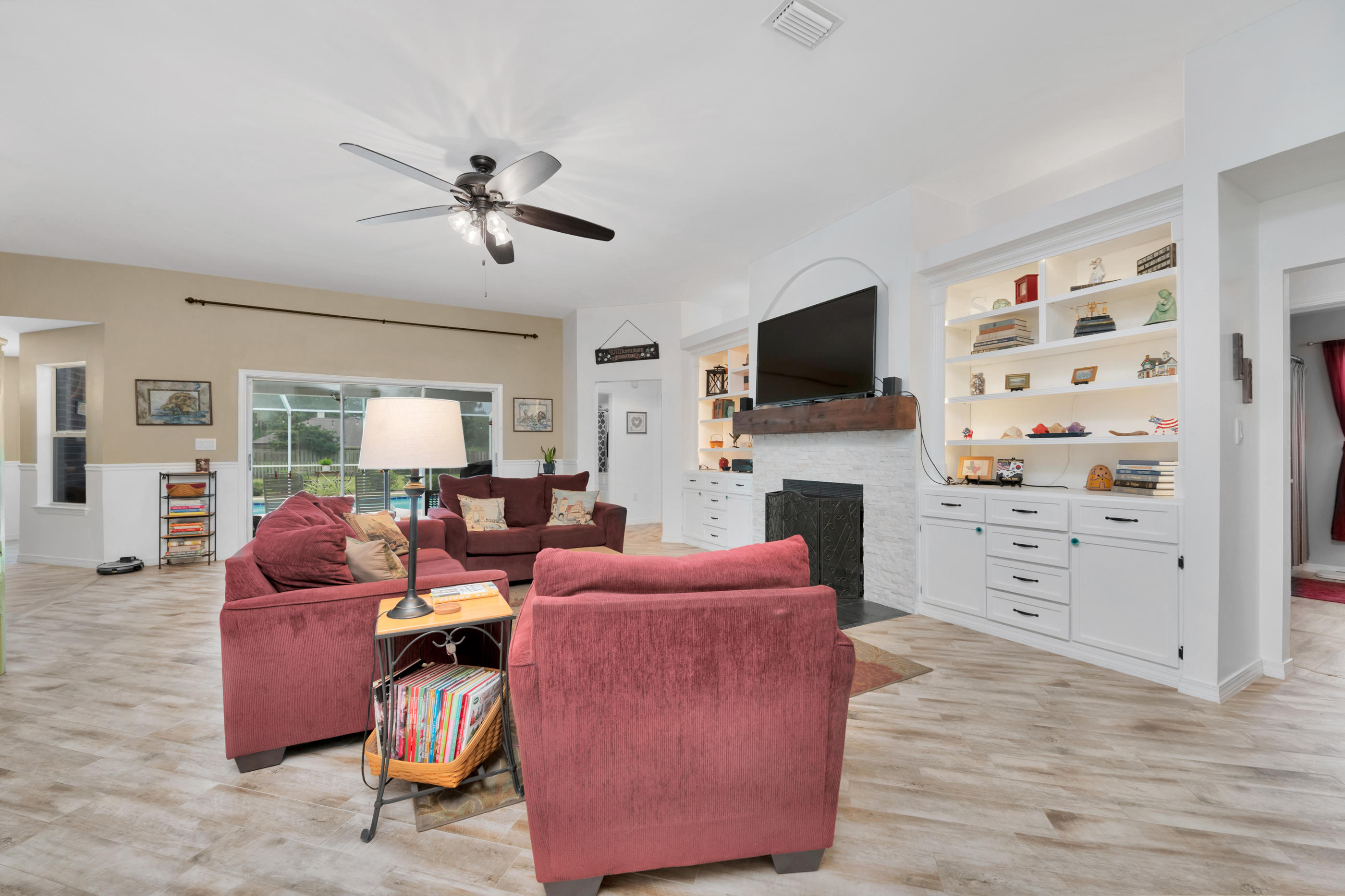 7159 Riverview Road Navarre, FL 32566 - Photo 11 of 36 a living room with furniture a flat screen tv and a fireplace