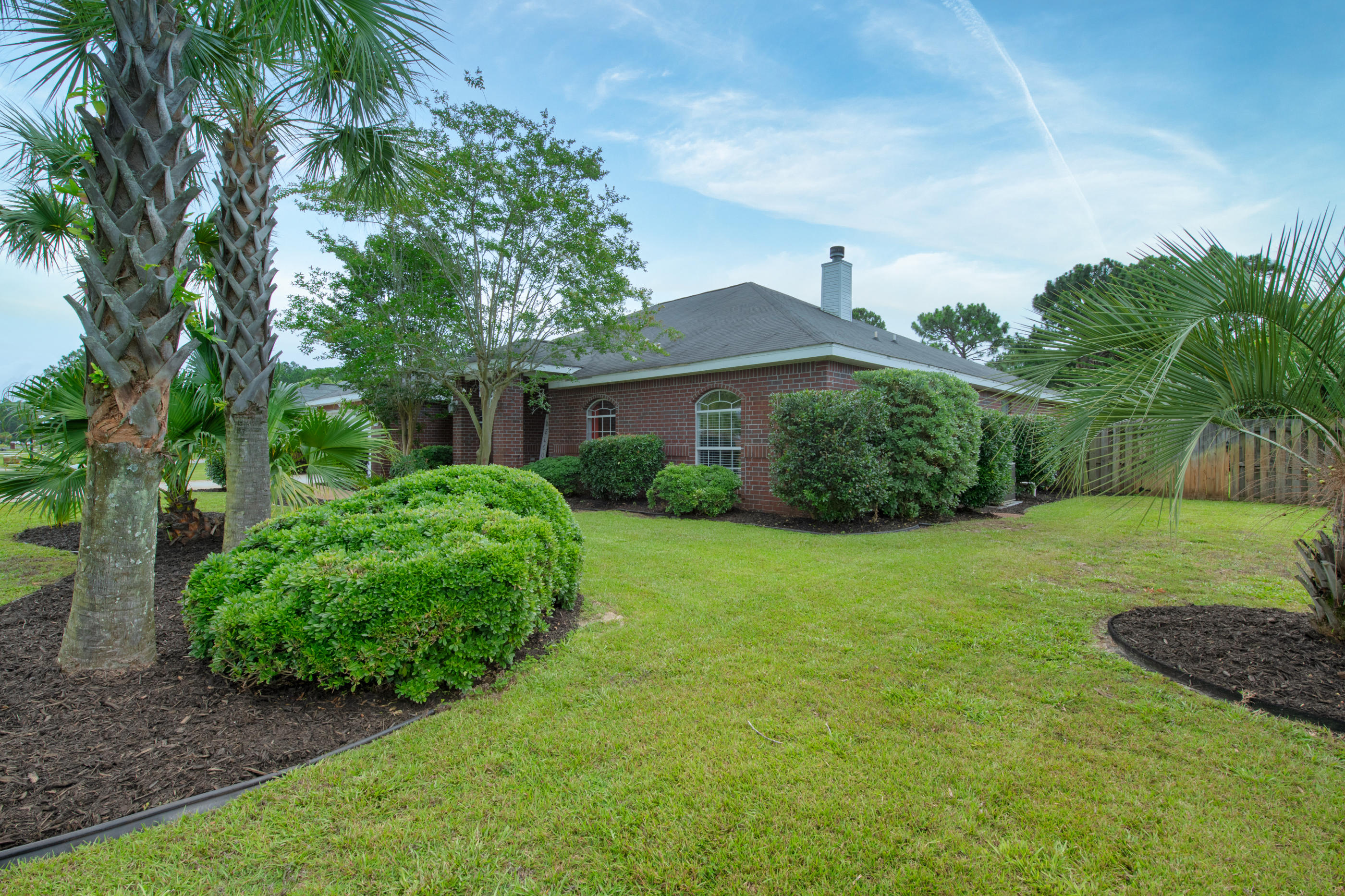 7159 Riverview Road Navarre, FL 32566 - Photo 3 of 36 a view of a big house with a big yard plants and large trees