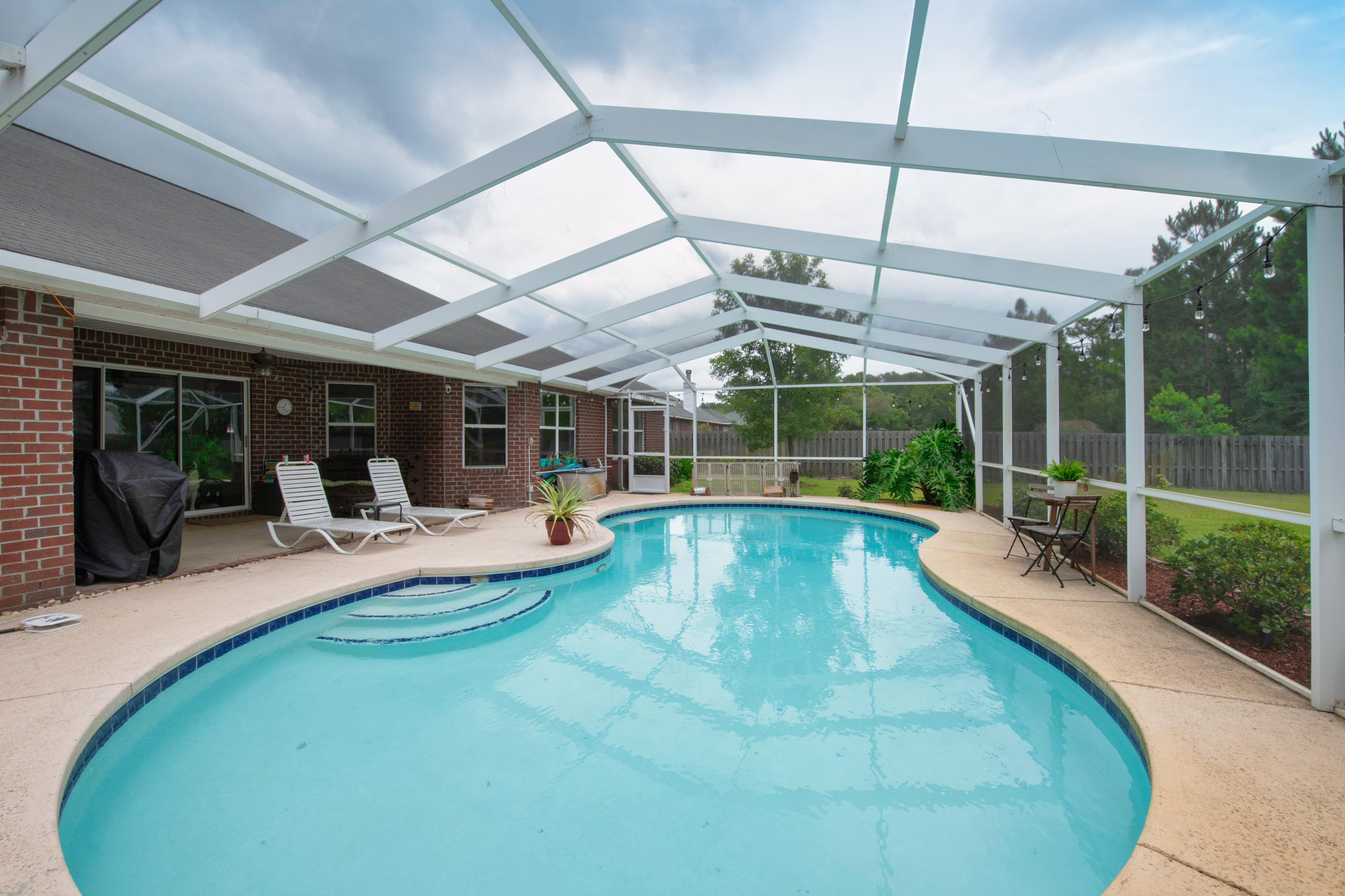 7159 Riverview Road Navarre, FL 32566 - Photo 31 of 36 a view of a swimming pool with a patio