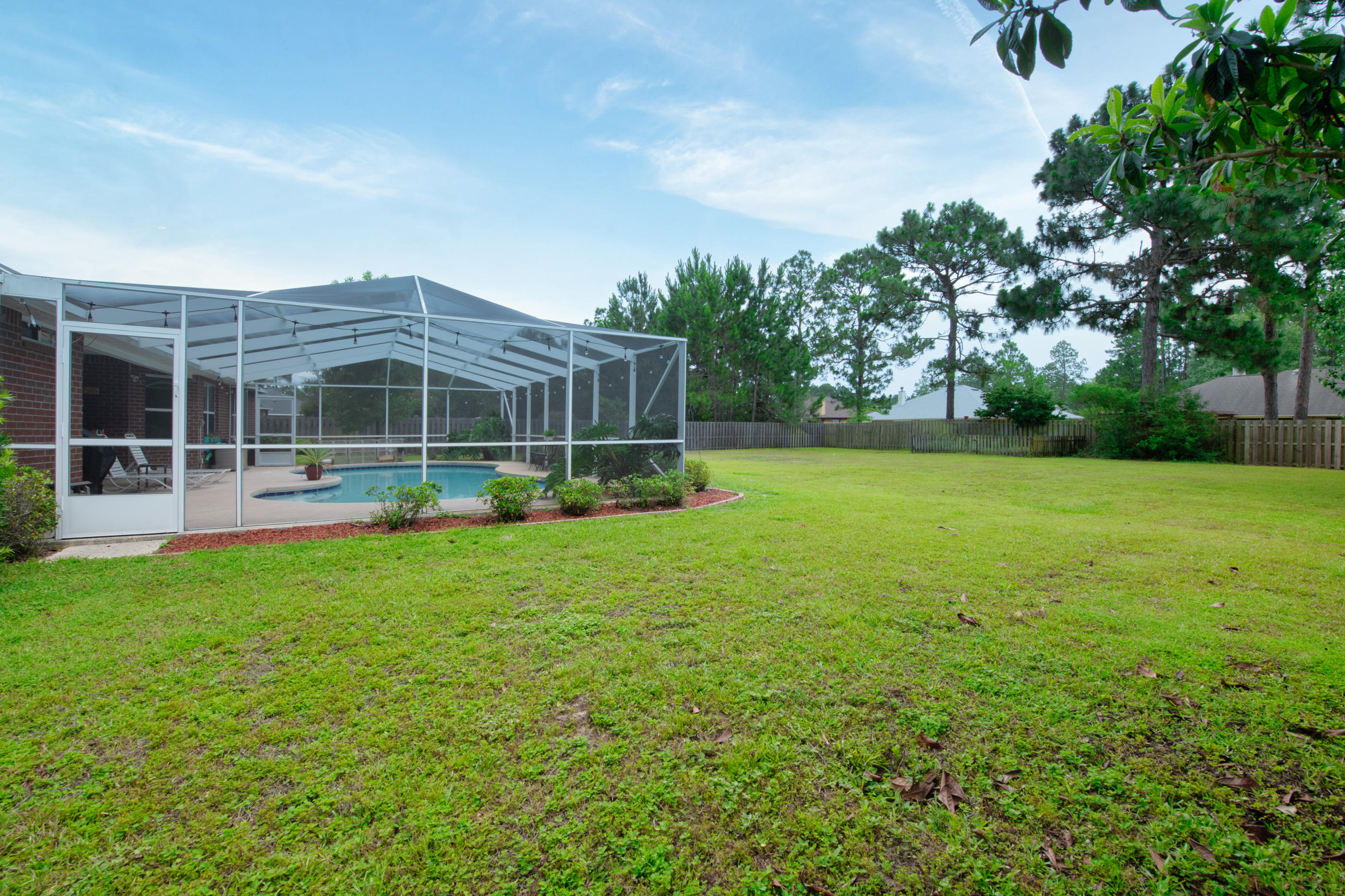 7159 Riverview Road Navarre, FL 32566 - Photo 32 of 36 a view of a house with a backyard and a garden