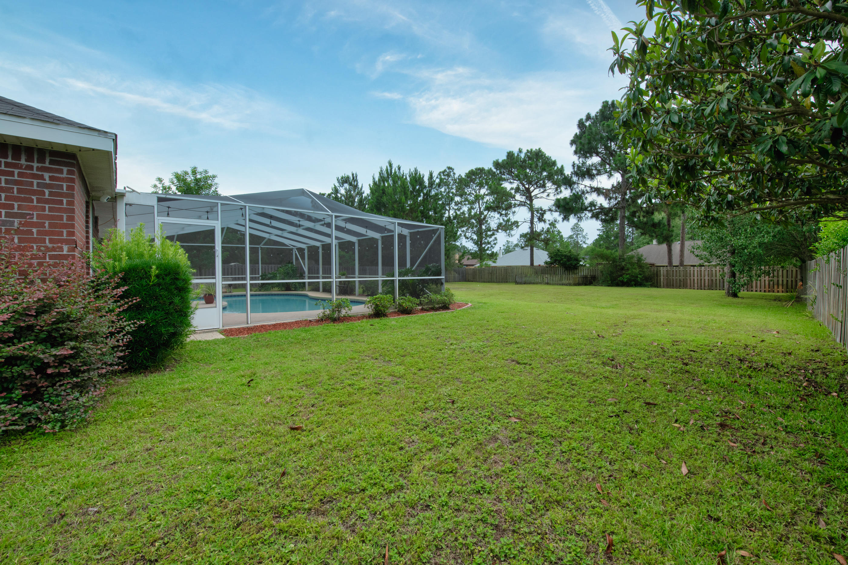 7159 Riverview Road Navarre, FL 32566 - Photo 33 of 36 a view of a house with a backyard and a patio