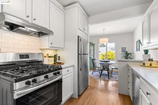 a kitchen with a stove a refrigerator and wooden floor