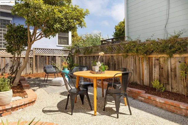 a patio with table and chairs and potted plants