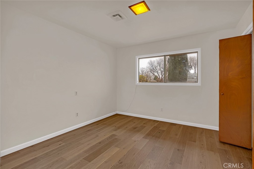 358 Sycamore Avenue Gustine, CA 95322 - Photo 13 of 37 a view of empty room with wooden floor and wall painting