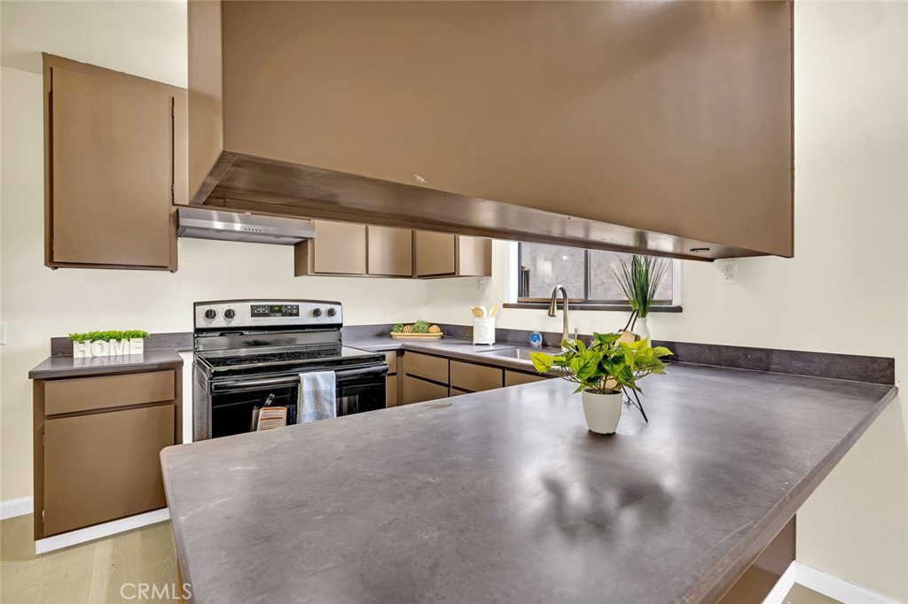358 Sycamore Avenue Gustine, CA 95322 - Photo 24 of 37 a kitchen with stainless steel appliances a stove a sink cabinets and a wooden floor