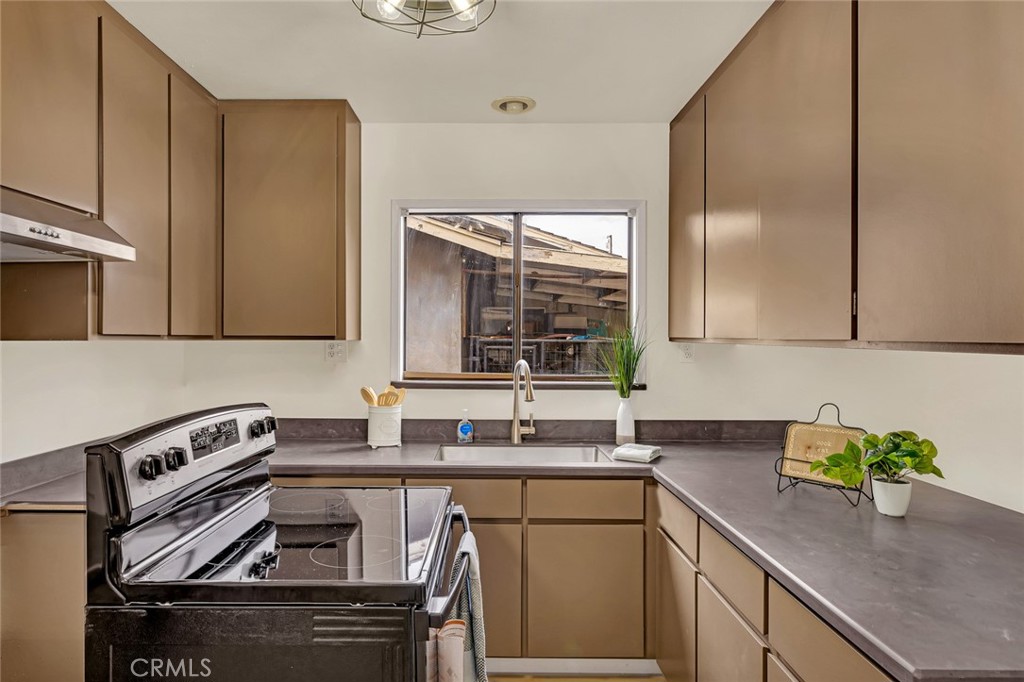 358 Sycamore Avenue Gustine, CA 95322 - Photo 25 of 37 a kitchen with a sink a stove cabinets and a window