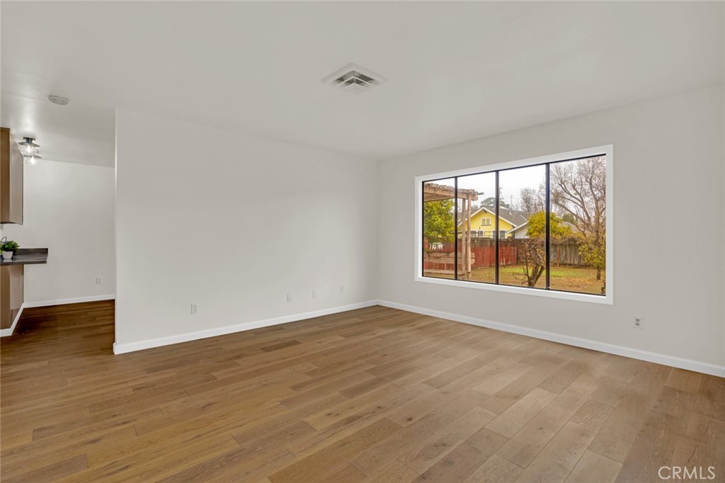 358 Sycamore Avenue Gustine, CA 95322 - Photo 7 of 37 an empty room with wooden floor and windows