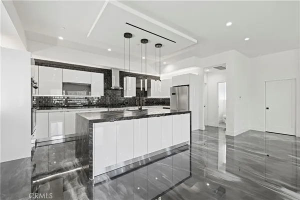 a kitchen with stainless steel appliances granite countertop a refrigerator and a stove