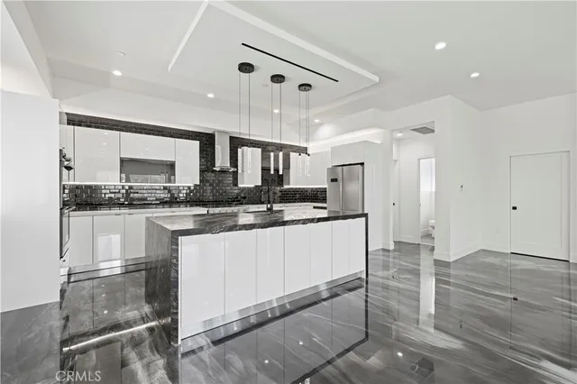 a kitchen with stainless steel appliances granite countertop a refrigerator and a stove