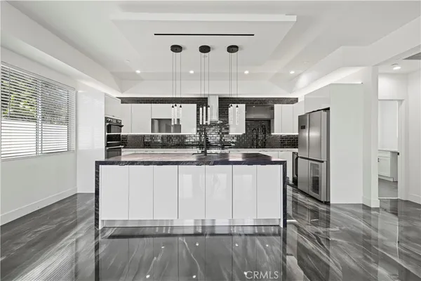 a kitchen with stainless steel appliances kitchen island granite countertop a sink and cabinets