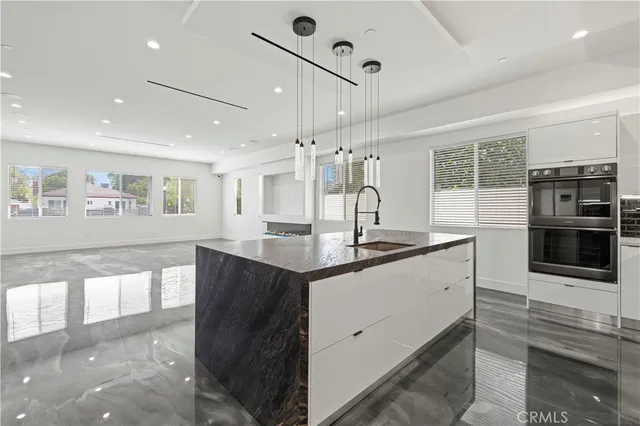 a kitchen with stainless steel appliances granite countertop a sink a refrigerator and a stove