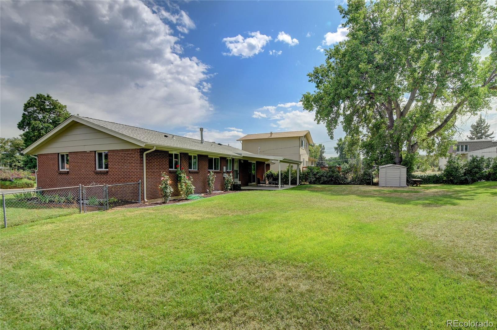 3295 Ward Road Wheat Ridge, CO 80033 - Photo 17 of 34 a front view of a house with a garden