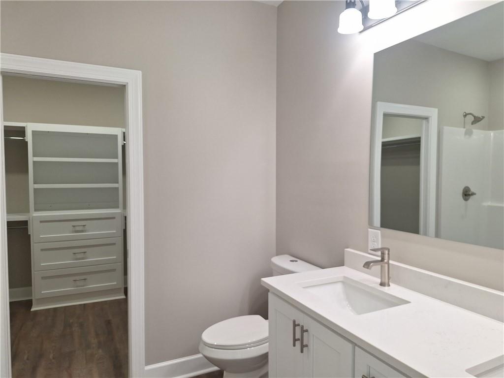 1390 Ben Brown Road Valley, AL 36854 - Photo 13 of 17 Bathroom featuring a white vanity with integrated sink, brushed nickel faucet, large wall mirror, and a built-in shower