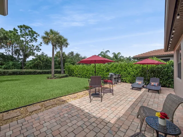 a view of a house with a big yard plants and large trees