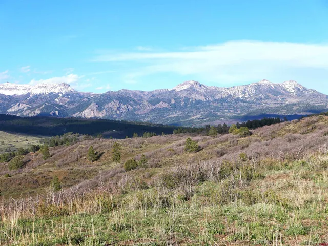 a view of mountain with sunset in background