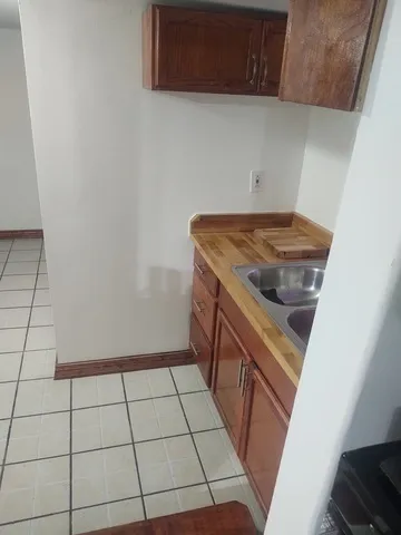 a view of an empty room with wooden floor and closet