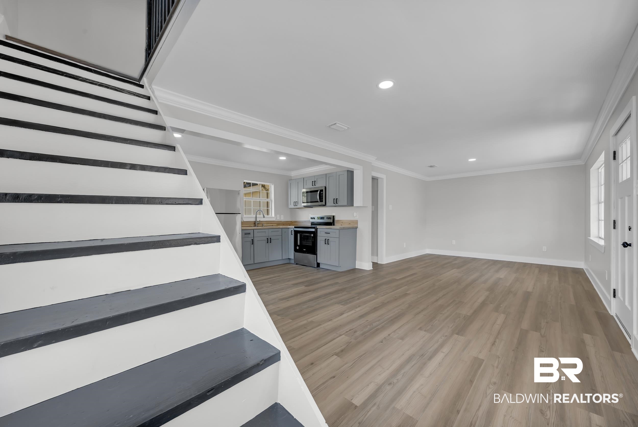 8351 Theodore Dawes Road Theodore, AL 36582 - Photo 32 of 46 Unfurnished living room featuring ornamental molding, light wood finished floors, stairs, and recessed lighting