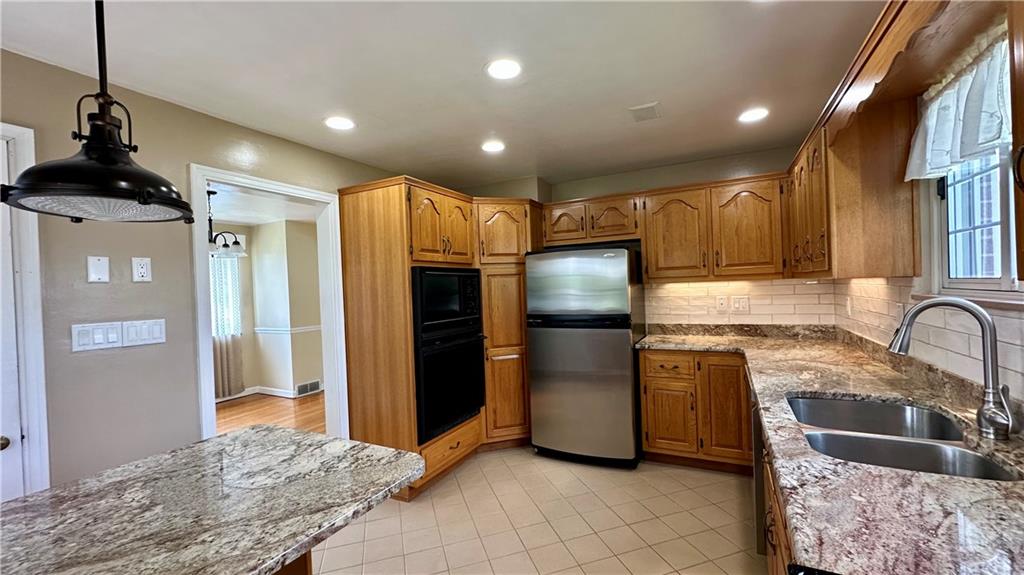 2231 Dellenbaugh Road Tarentum, PA 15084 - Photo 23 of 50 a kitchen with stainless steel appliances granite countertop a refrigerator a stove and a sink with wooden cabinets