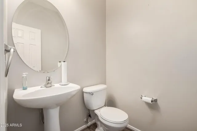 a bathroom with a sink a toilet and a mirror