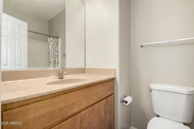 a bathroom with a granite countertop sink toilet and mirror